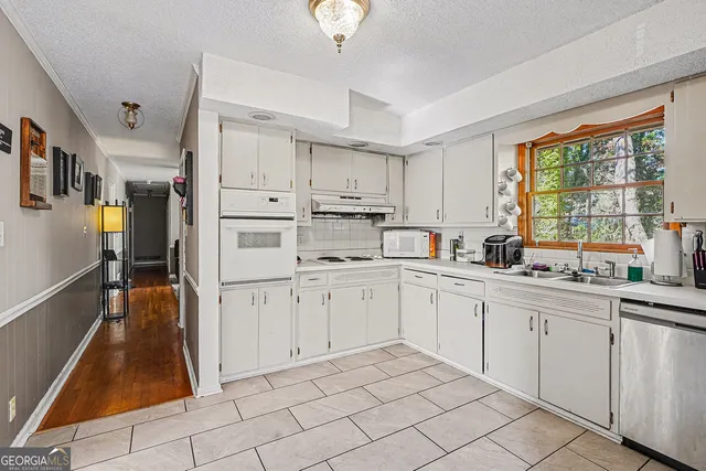 a kitchen with white cabinets and white appliances