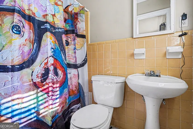 a bathroom with a toilet sink and mirror