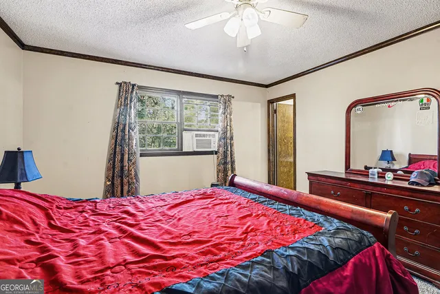 a bedroom with a large bed and a chandelier