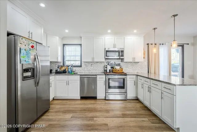 a kitchen with stainless steel appliances a refrigerator sink and cabinets