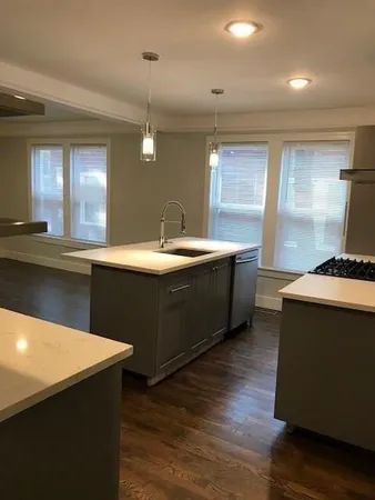 a kitchen with sink cabinets and wooden floor