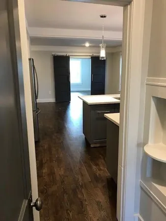 a view of a hallway and a livingroom with furniture