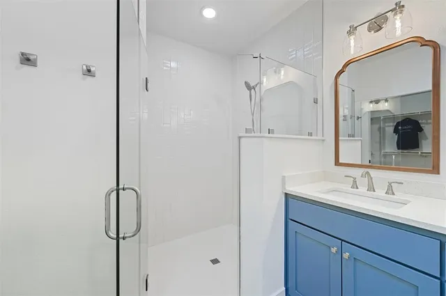 a bathroom with a shower sink and mirror