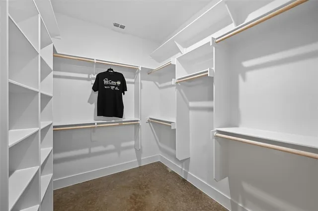 a view of walk in closet with empty racks