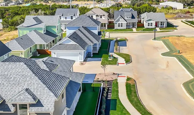 an aerial view of residential houses with outdoor space and swimming pool