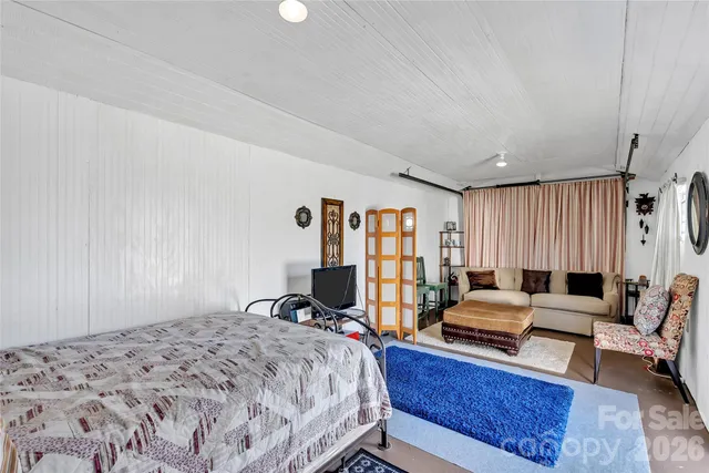 a bedroom with a bed a couch and a dresser in it