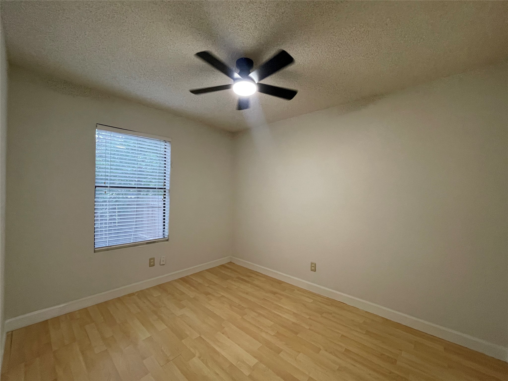 2031 Redwing Way Round Rock, TX 78664 - Photo 18 of 25 A quiet, well-lit bedroom features durable hardwood flooring and a functional ceiling fan for comfort.