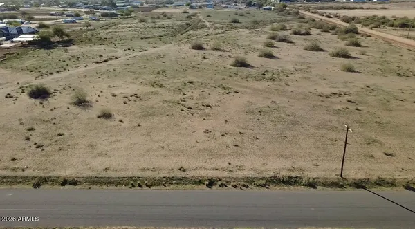 a view of a dry field with trees