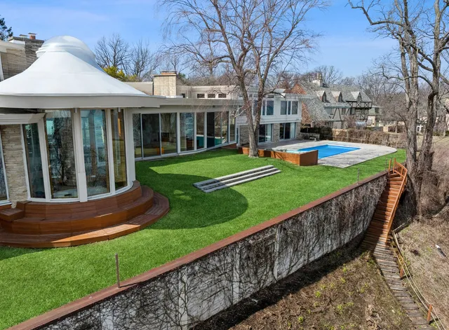 a backyard of a house with table and chairs under an umbrella