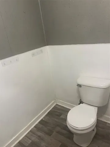 a white toilet sitting next to a white wall