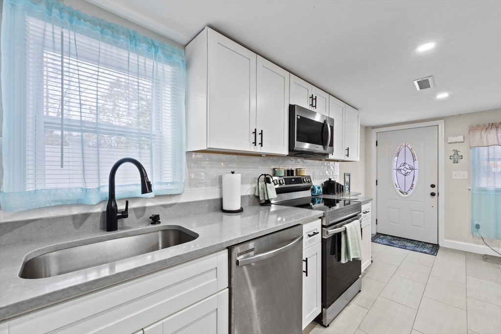 23 Bennett Lane Lancaster, MA 01523 - Photo 9 of 29 a kitchen with stainless steel appliances granite countertop a sink stove and a refrigerator