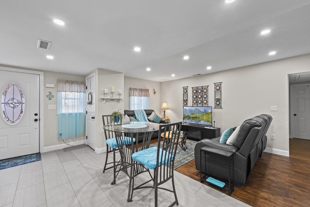 23 Bennett Lane Lancaster, MA 01523 - Photo 10 of 29 a living room with furniture a wooden floor and a painting on the wall