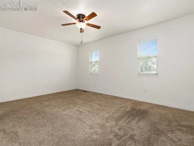 an empty room with a window and a ceiling fan