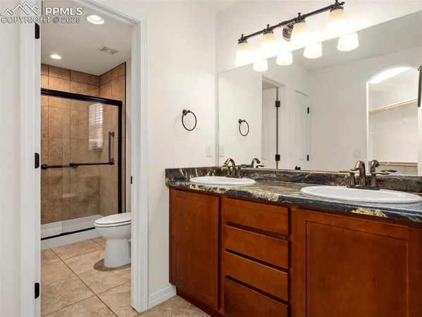 a bathroom with a double vanity sink mirror and toilet