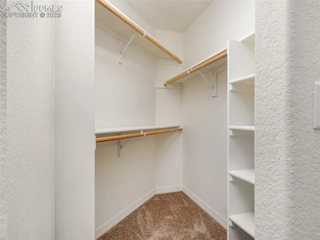 a view of walk in closet with empty racks