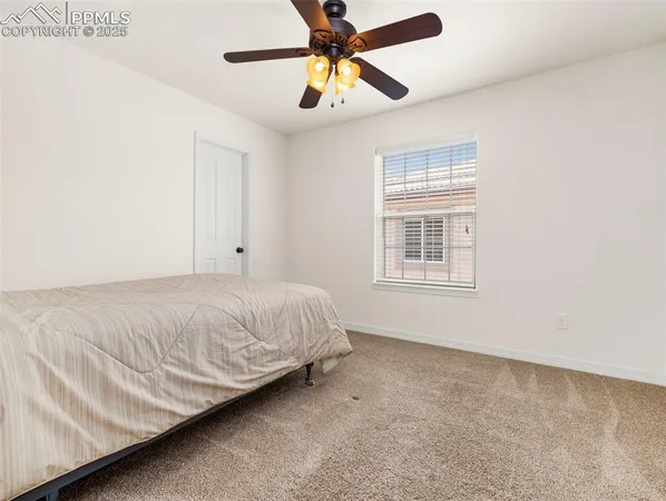 a bedroom with a bed chandelier and a window