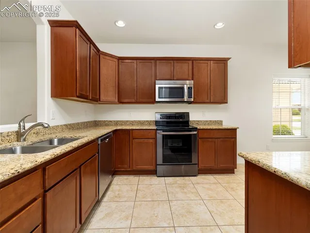a kitchen with stainless steel appliances granite countertop a stove microwave and sink