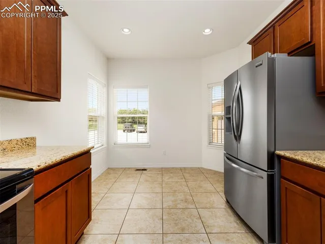 a kitchen with stainless steel appliances granite countertop a refrigerator a sink and a stove