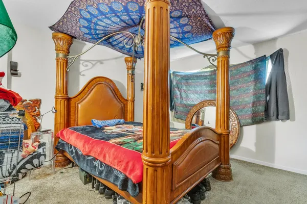 a bedroom with a bed and a flat tv screen on dresser