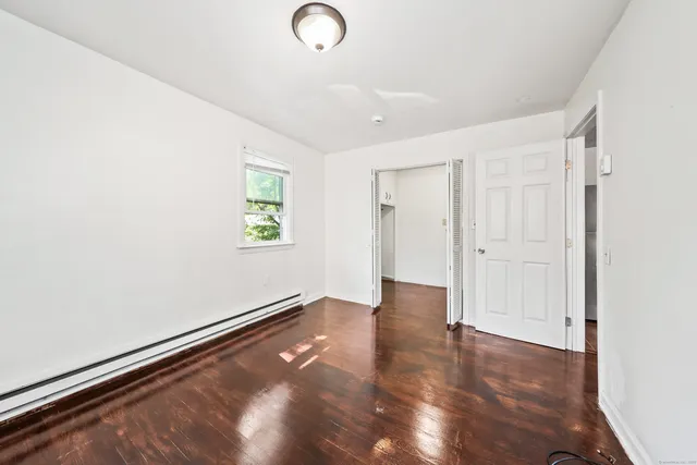 a view of an empty room with wooden floor