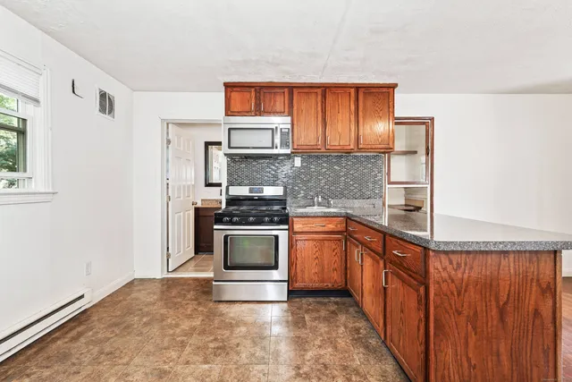 a kitchen with stainless steel appliances granite countertop a stove a sink and a refrigerator