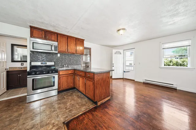a kitchen with stainless steel appliances kitchen island granite countertop a stove a sink and a refrigerator