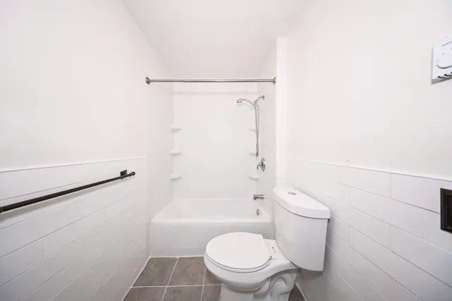 a white toilet sitting next to a bath tub