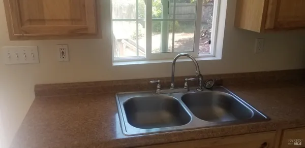 a close view of a sink a faucet and a stove in a kitchen