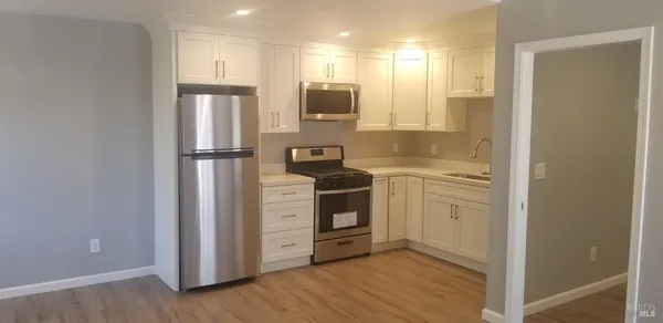 a kitchen with white cabinets and a sink