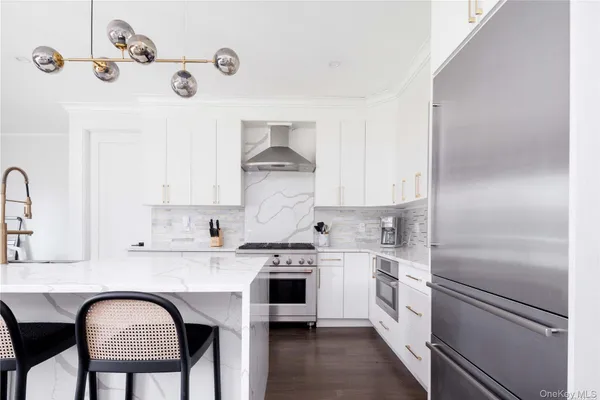 a kitchen with a refrigerator and white cabinets