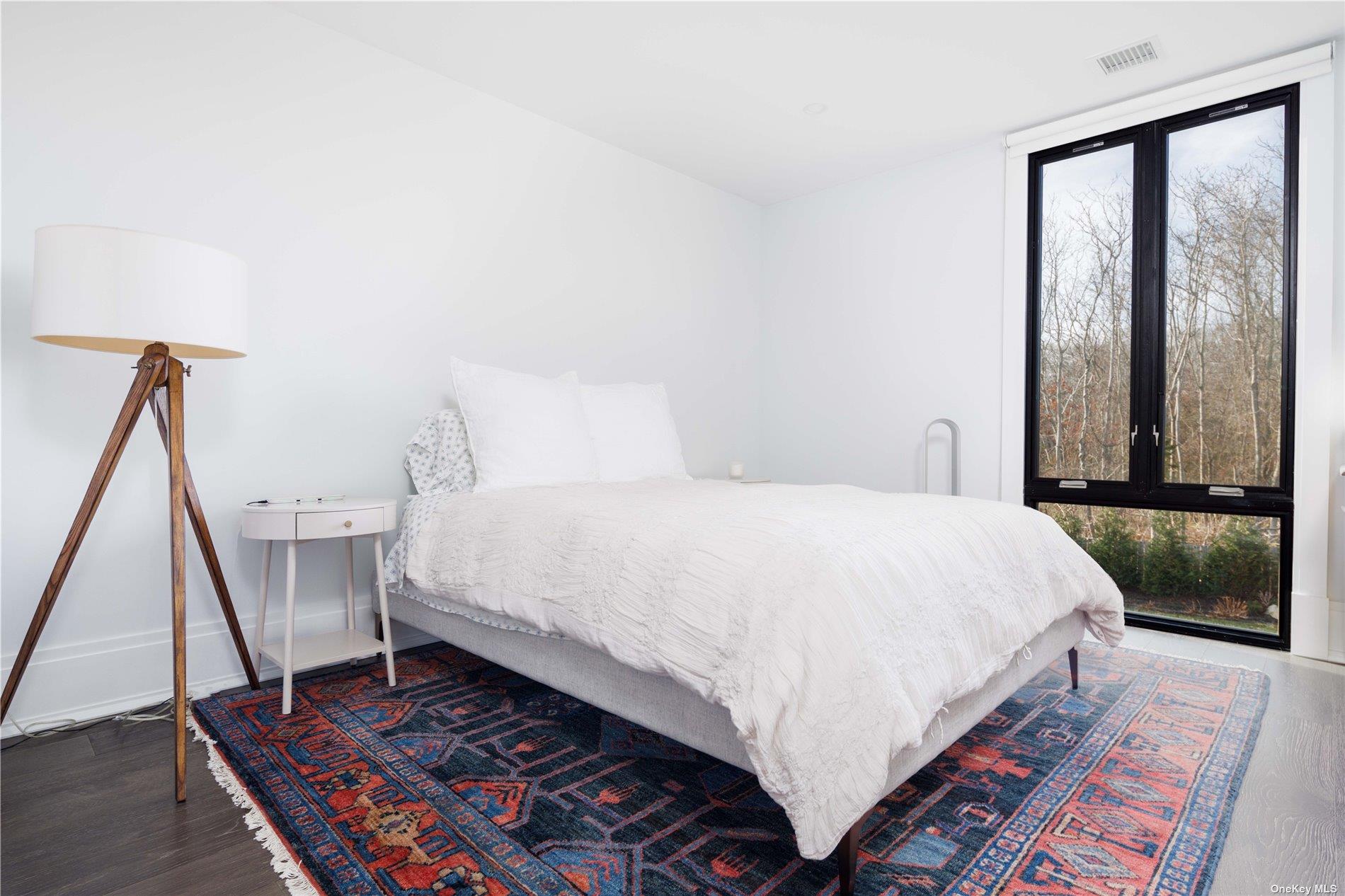 2415 Cox Neck Road Mattituck, NY 11952 - Photo 4 of 10 a large bed sitting in a bedroom next to a window