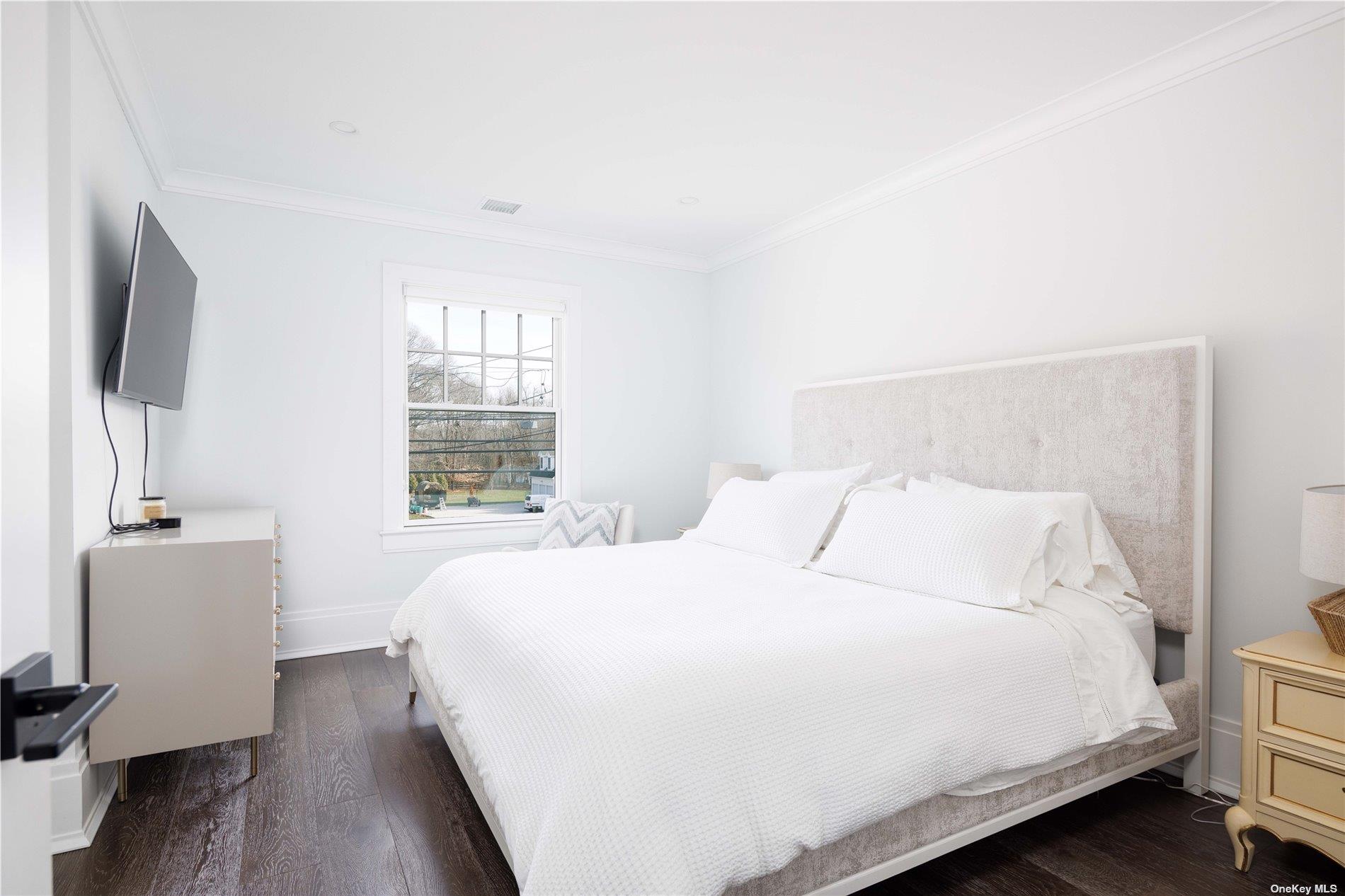 2415 Cox Neck Road Mattituck, NY 11952 - Photo 5 of 10 a bedroom with a bed and a flat screen tv