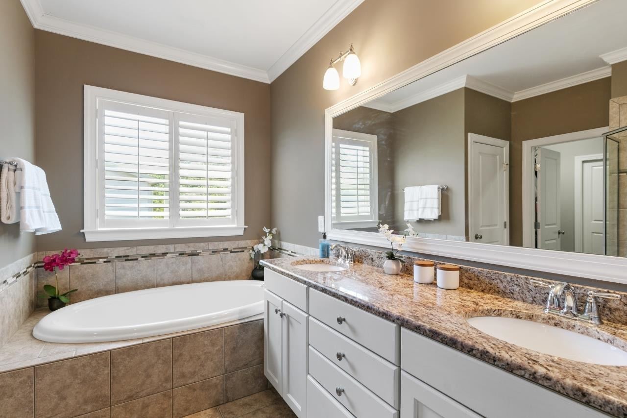 2800 Romealia Lane Raleigh, NC 27613 - Photo 20 of 33 The owner's bath features dual vanities, the same high quality cabinets with dovetail drawer construction, granite counters, tile floors, a separate soaking tub and a walk-in shower. The owner's closet is accessed from the bathroom. Master Bath/Spa