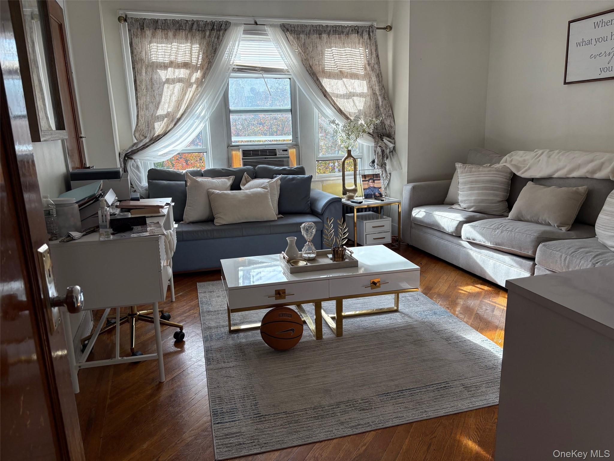 140-99 Burden Crescent, Unit 2 Queens, NY 11435 - Photo 2 of 8 a living room with furniture a large window and wooden floor