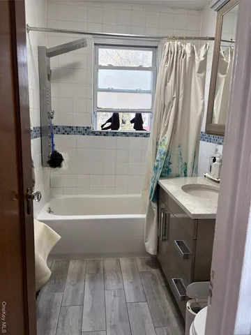 a bathroom with a sink a toilet a mirror and shower