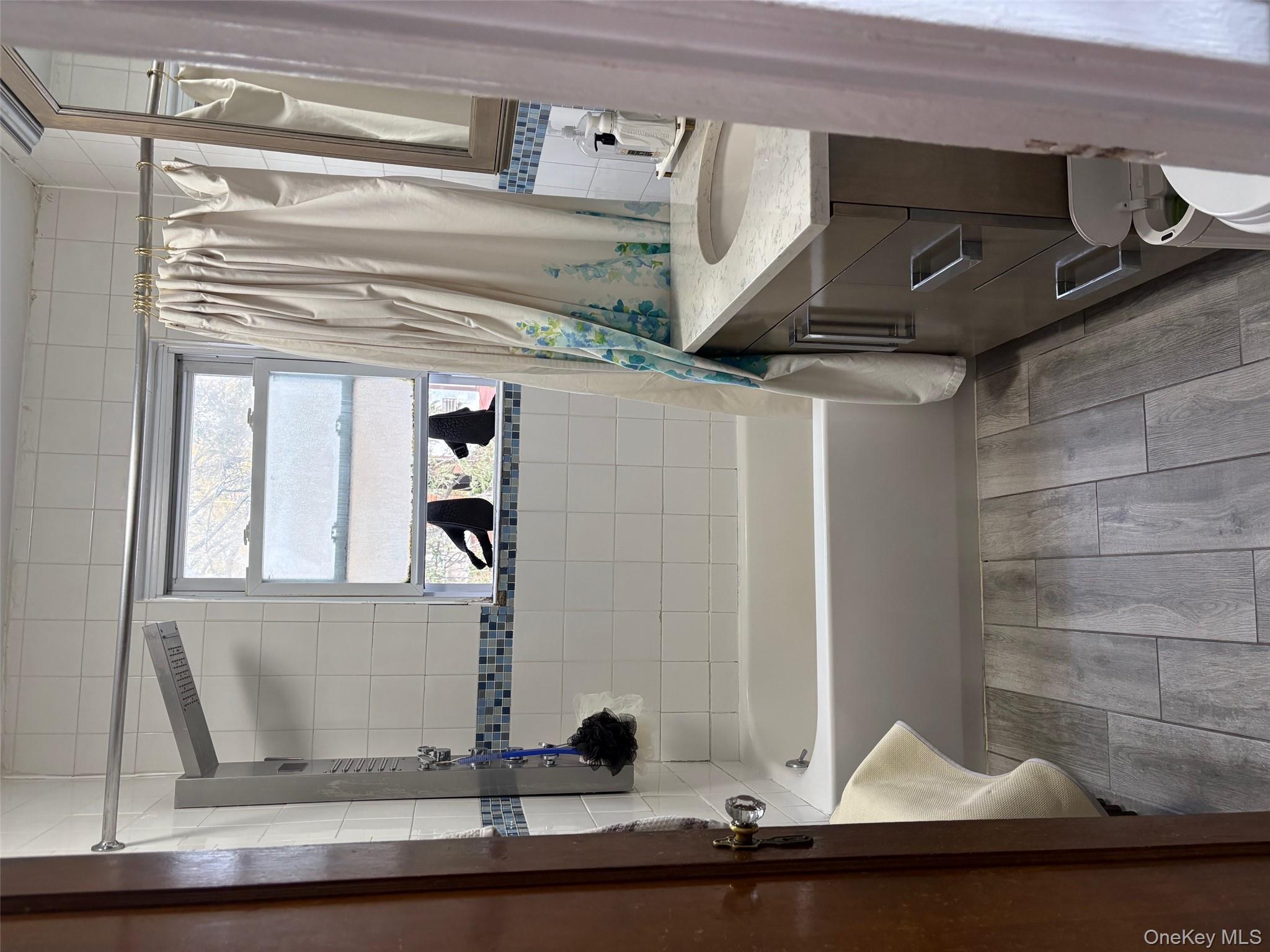 140-99 Burden Crescent, Unit 2 Queens, NY 11435 - Photo 8 of 8 a bathroom with a sink a toilet a mirror and shower