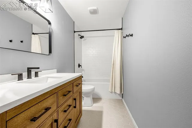 a bathroom with a granite countertop sink mirror vanity and toilet