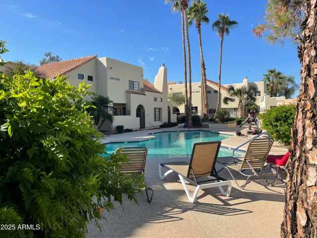 a view of a patio with table and chairs potted plants and palm tree