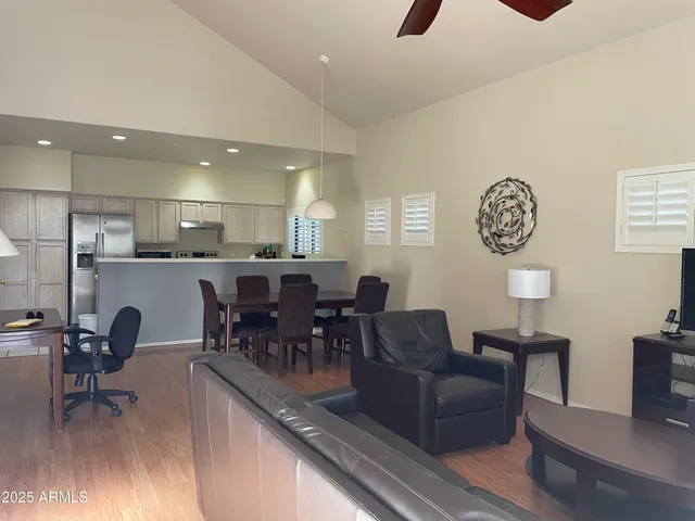 a living room with furniture a table and kitchen view