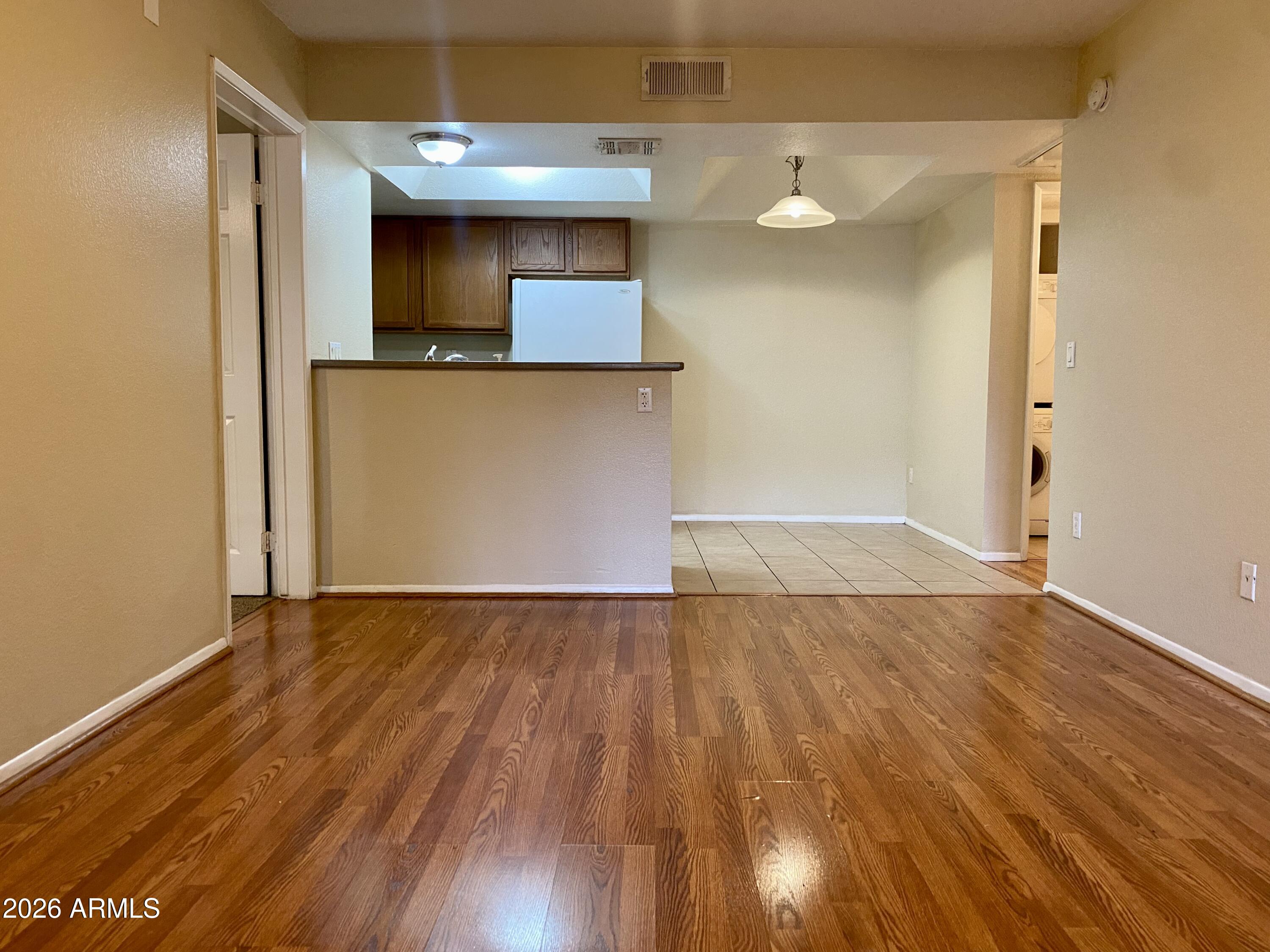 an empty room with wooden floor and cabinet