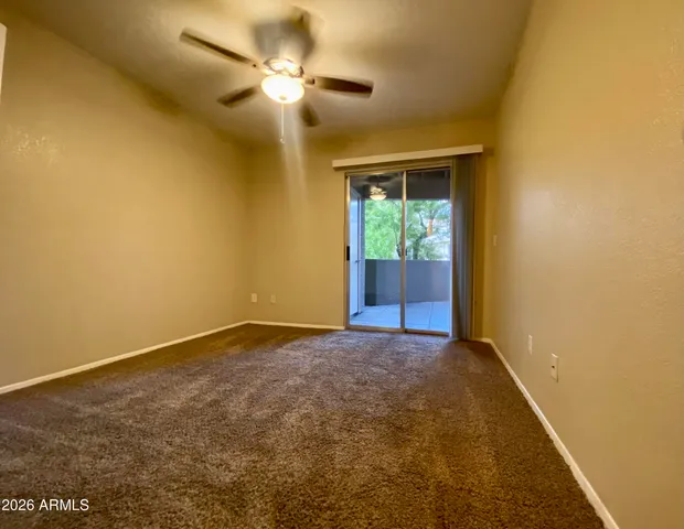 a view of an empty room with a chandelier fan
