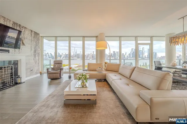 a living room with fireplace furniture and floor to ceiling windows