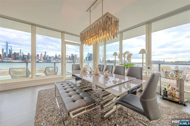 a dining room with furniture water view and a floor to ceiling window