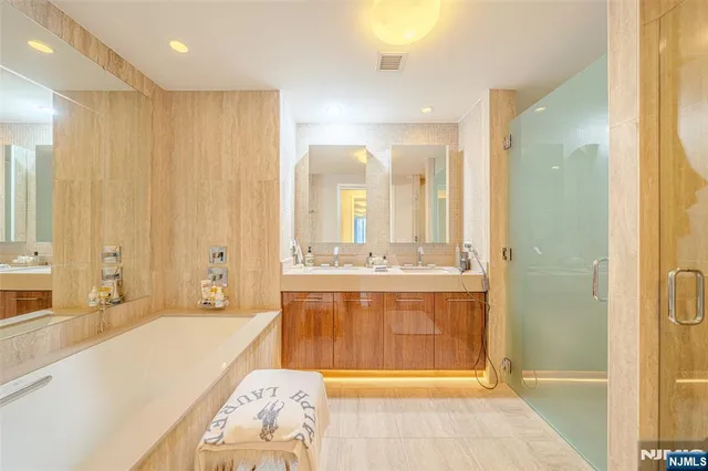 a spacious bathroom with a tub sink and mirror