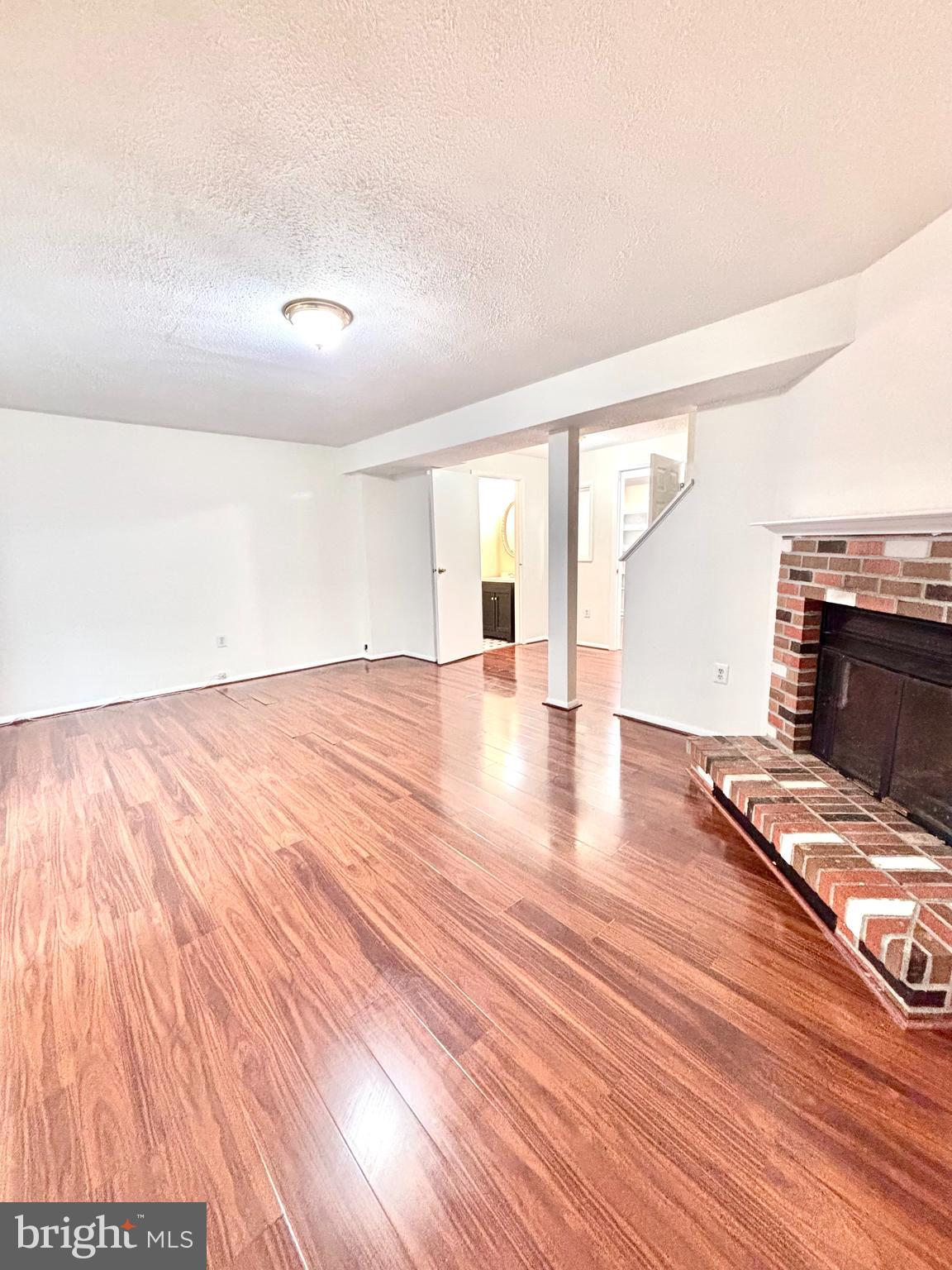 6226 Hillside Road Springfield, VA 22152 - Photo 35 of 37 a view of an empty room with wooden floor and a fireplace