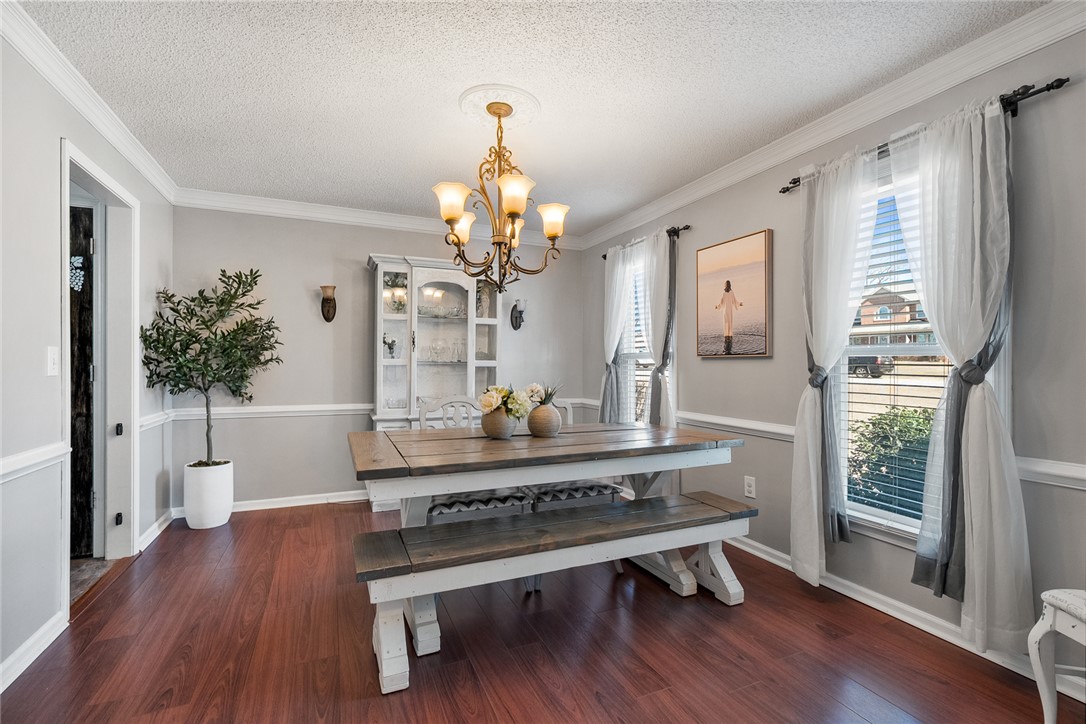 112 C-10-220 Anderson, SC 29621 - Photo 6 of 45 This luminous dining area features rich wood flooring and crown molding, creating an inviting space for gatherings.