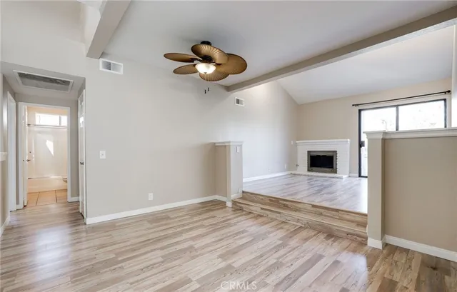 a view of empty room with wooden floor