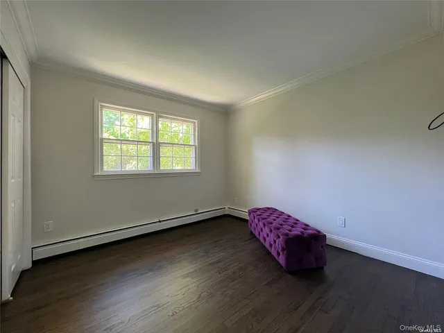 an empty room with wooden floor and window