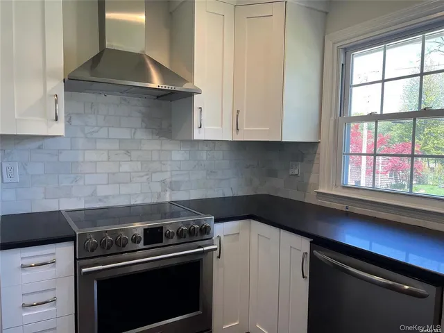 a kitchen with a stove and white cabinets