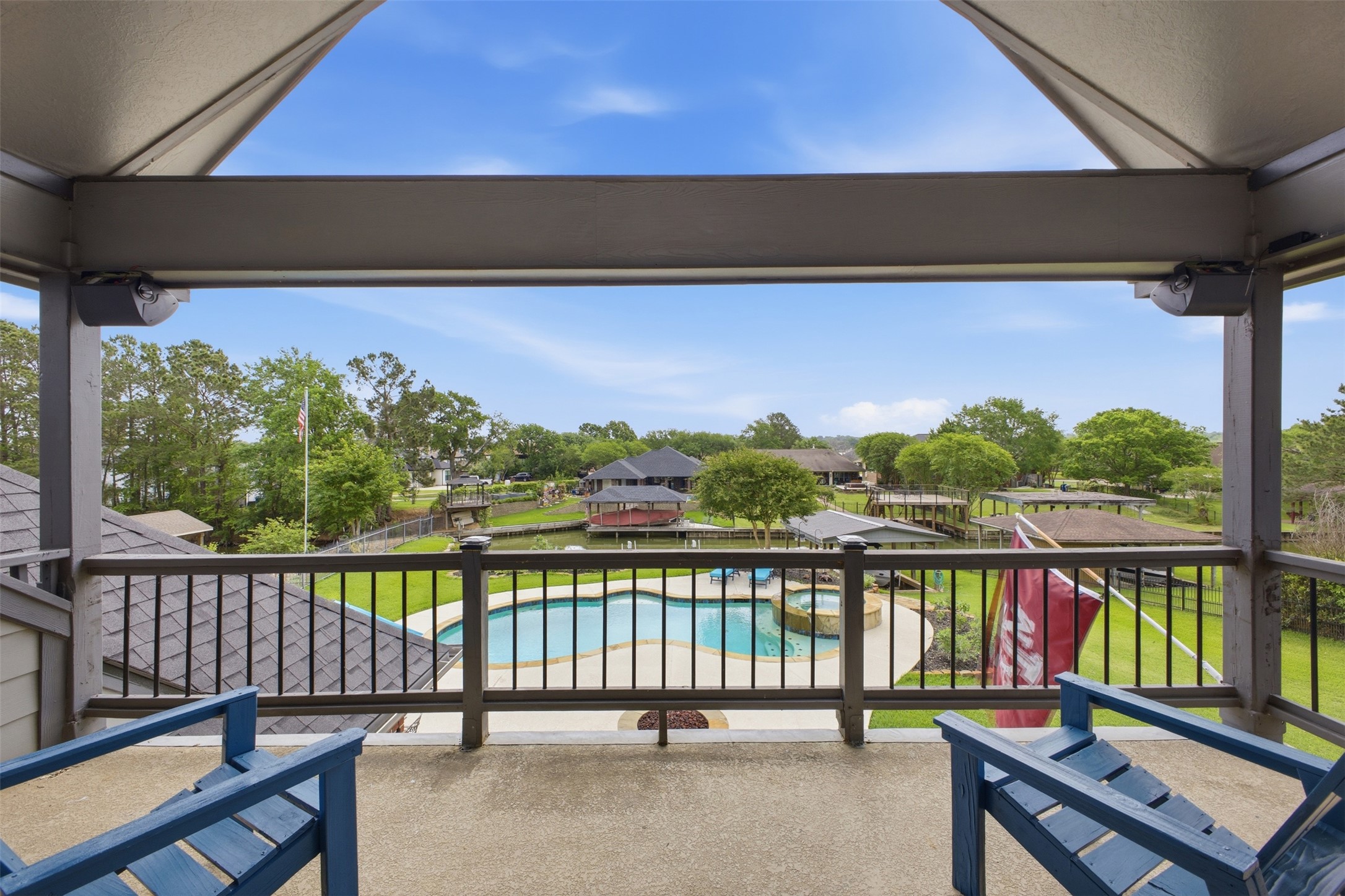 12710 Aries Loop Willis, TX 77318 - Photo 31 of 40 An expansive outdoor living space with a covered balcony, offering elevated views of the property's pool and surrounding green landscape